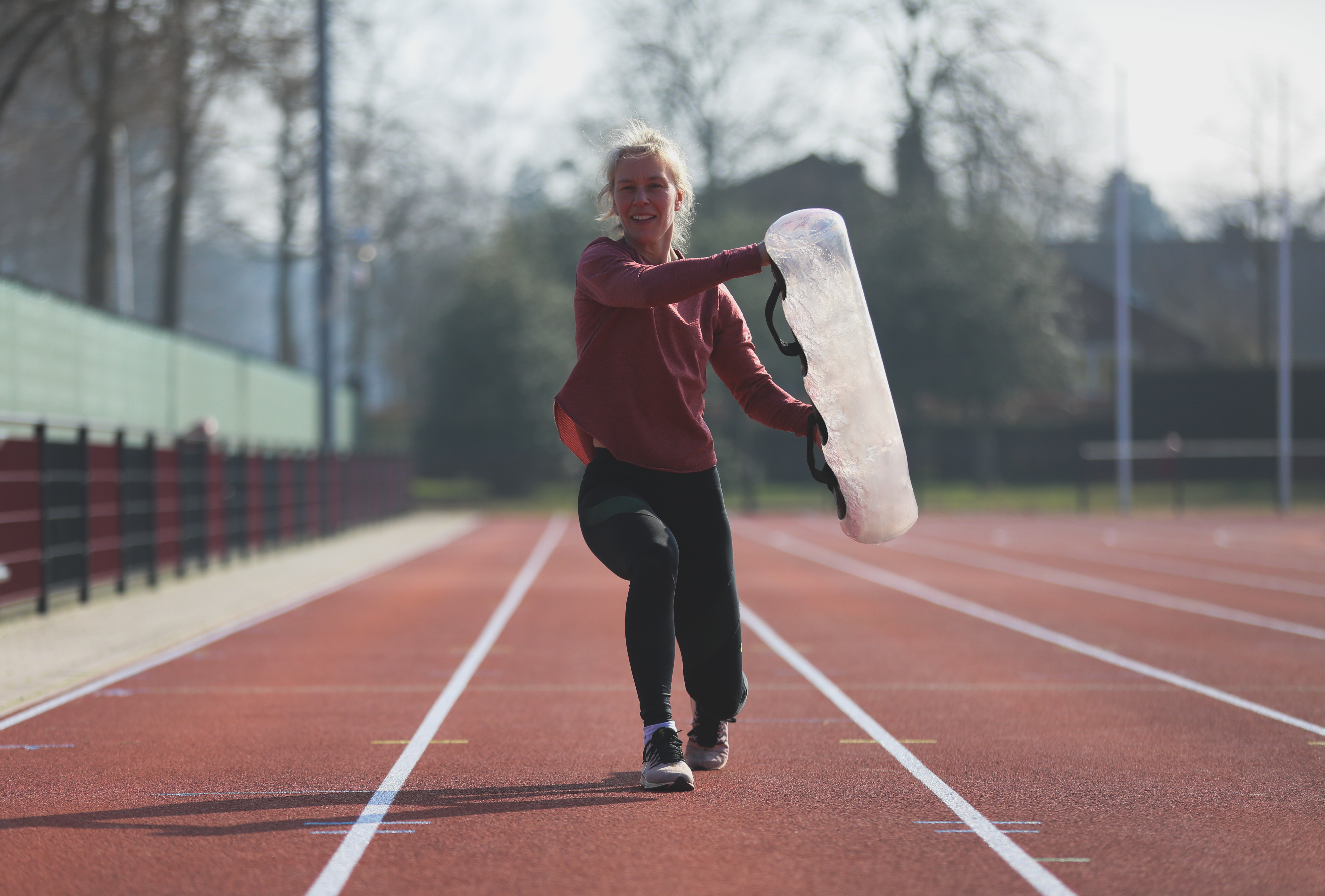 hardloopster bezig met krachttraining op de atletiekbaan